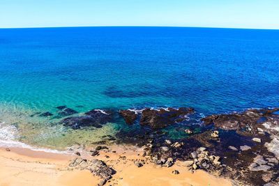 Scenic view of beach against blue sky