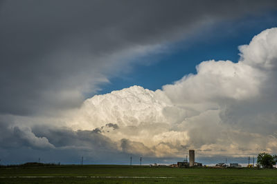 Panoramic view of factory against cloudy sky