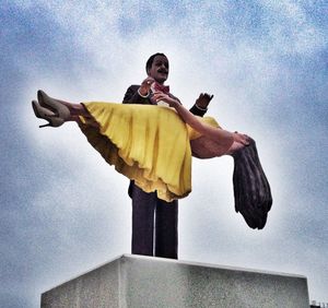 Low angle view of woman standing against sky