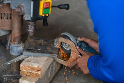 Worker grinding to cut a steel without gloves protective hands.