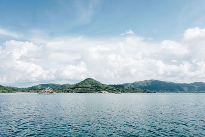 Scenic view of sea and mountains against sky