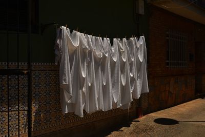 Towels drying on clotheslines against house