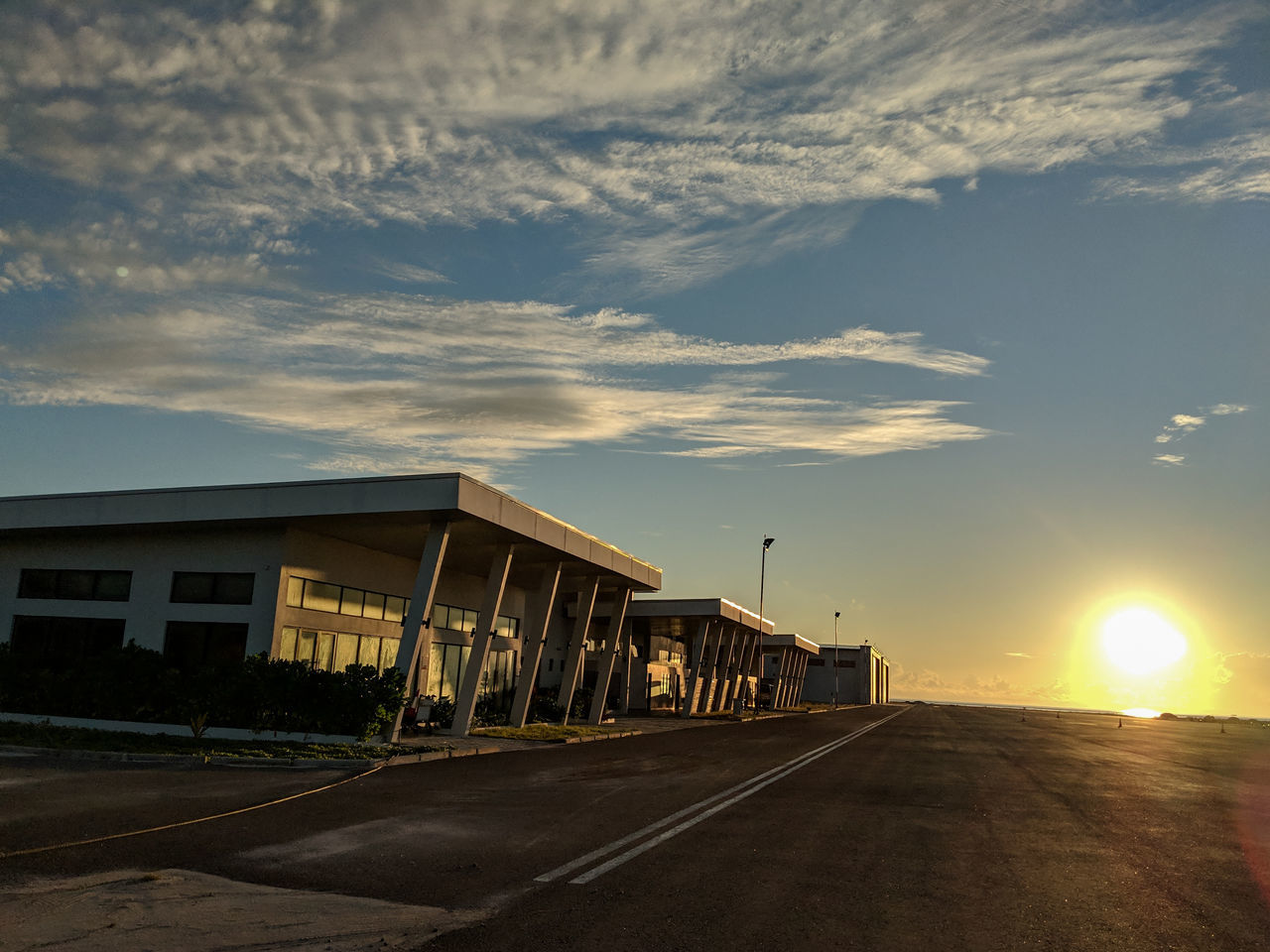 sky, cloud - sky, architecture, built structure, sunset, building exterior, road, transportation, nature, sun, street, sunlight, building, no people, outdoors, city, the way forward, direction, empty, sunbeam