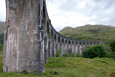 Arch bridge on mountain against sky