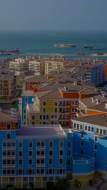 High angle view of buildings by sea against sky