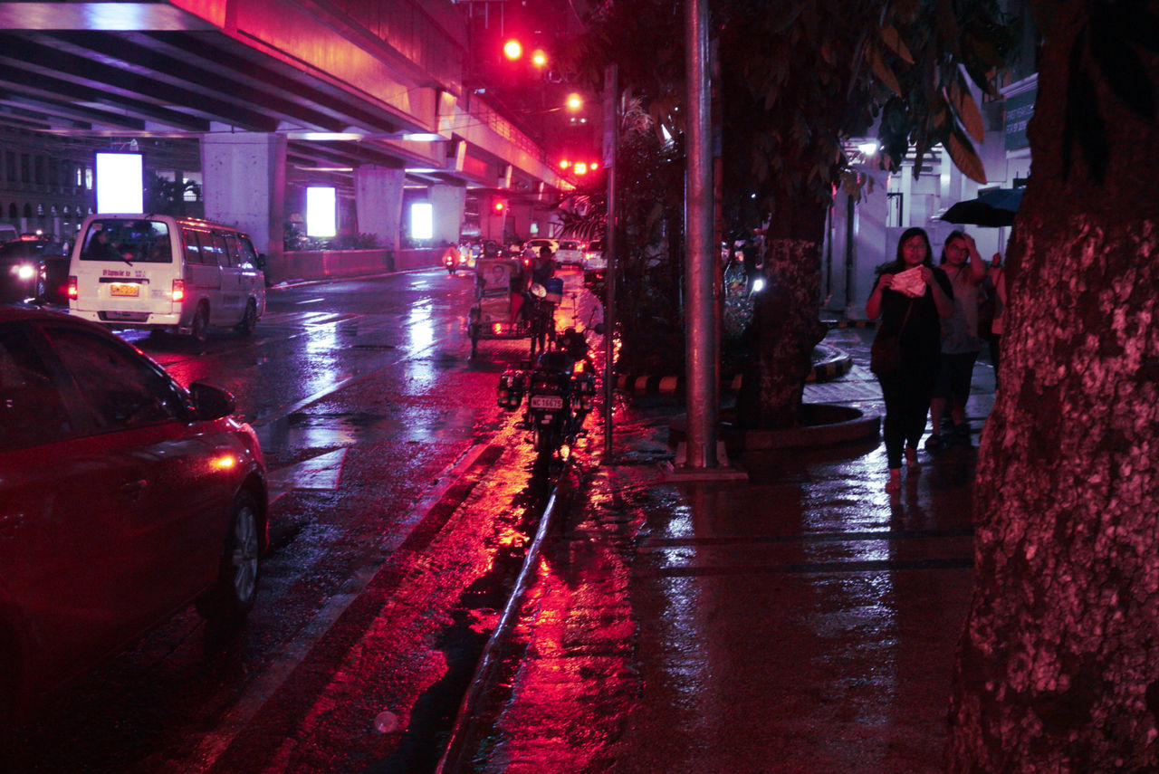 mode of transportation, car, motor vehicle, transportation, land vehicle, city, illuminated, wet, street, architecture, night, real people, rain, city life, road, built structure, people, incidental people, men, rainy season