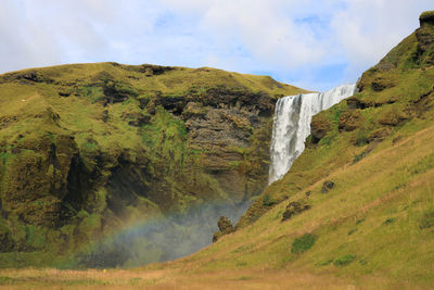 Scenic view of waterfall against sky