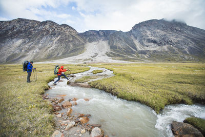 People on mountain against sky