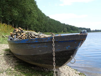 Boat moored on lake against sky