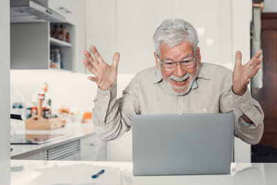 Portrait of man using laptop at home