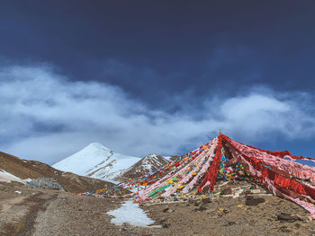 Multi colored flags on landscape against sky