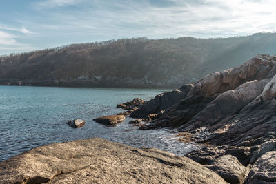 Scenic view of sea and mountains against sky