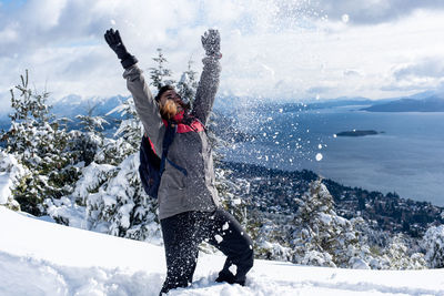 Woman with umbrella standing on snow covered landscape during winter