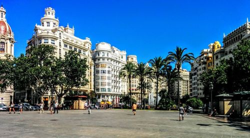 Buildings in city against clear blue sky