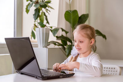 The girl learns , communicates, talks, through a computer / laptop