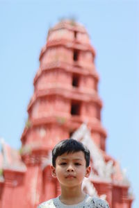 Portrait of boy at temple against clear sky