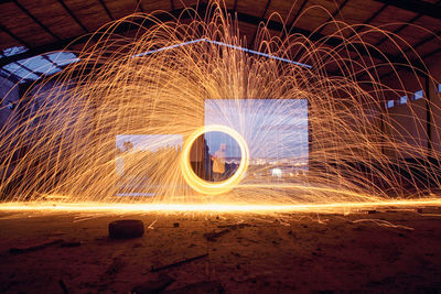 Man standing amidst wire wool at night