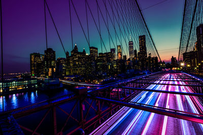 Illuminated suspension bridge in city at night