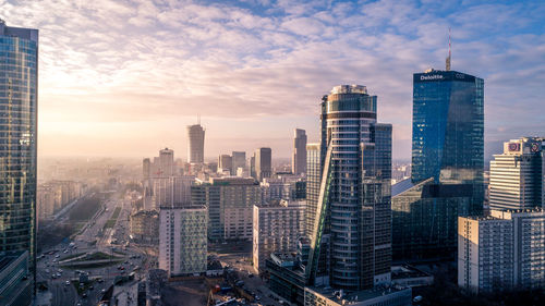 Aerial view of cityscape against cloudy sky