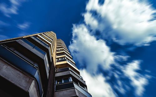 Low angle view of modern building against cloudy sky