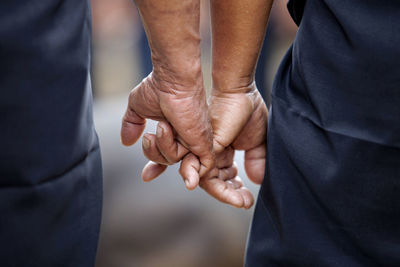 Midsection of friends making pinky promise