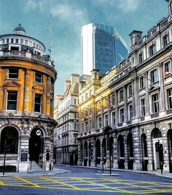 Buildings in city against cloudy sky