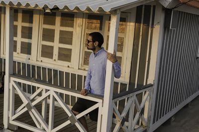 Full length of man standing by railing against building