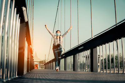 Man standing on bridge against sky during sunset