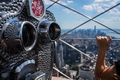 Close-up of coin-operated binoculars against cityscape