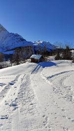 Snow covered landscape against blue sky