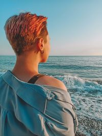 Woman looking at sea against clear sky