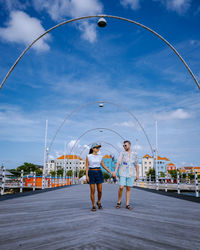 Woman with umbrella against sky in city