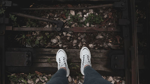 Low section of man standing on railroad track