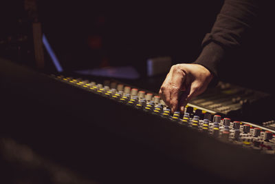 Cropped hand of musician adjusting sound mixer in nightclub