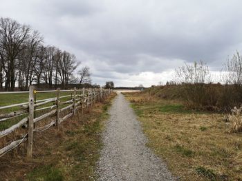 Road amidst field against sky