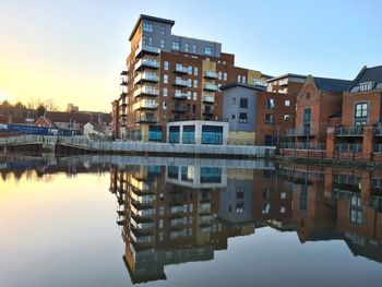 Reflection of buildings in river against sky