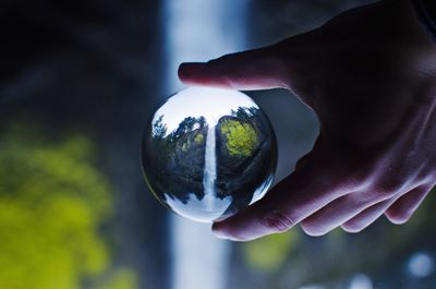 Close-up of hand holding crystal ball