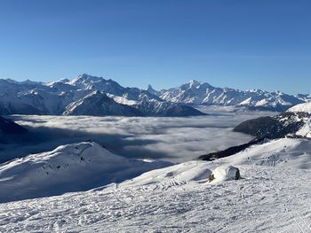 Scenic view of snowcapped mountains against clear blue sky