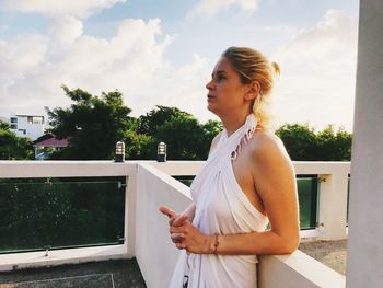 Woman looking at camera against sky
