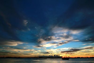 Scenic view of sea against dramatic sky during sunset