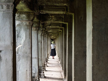 Rear view of woman walking in corridor of building