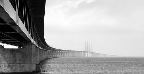 Bridge over river against cloudy sky