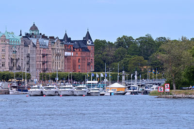 Sailboats in river against buildings