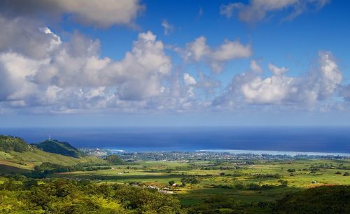 Scenic view of field and sea against sky