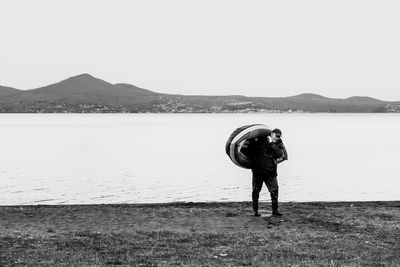 Rear view of man standing on mountain against sky