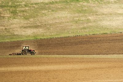 Side view of a tractor on dirt road