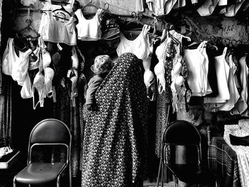 Rear view of woman carrying child at clothes store