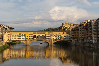 Bridge over river in city against sky