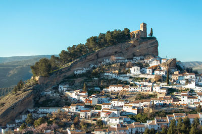 Old buildings in city against clear blue sky