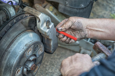 Midsection of mechanic repairing car